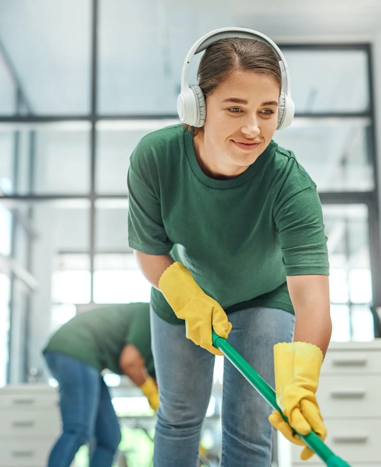 a person wearing headphones and gloves cleaning floor